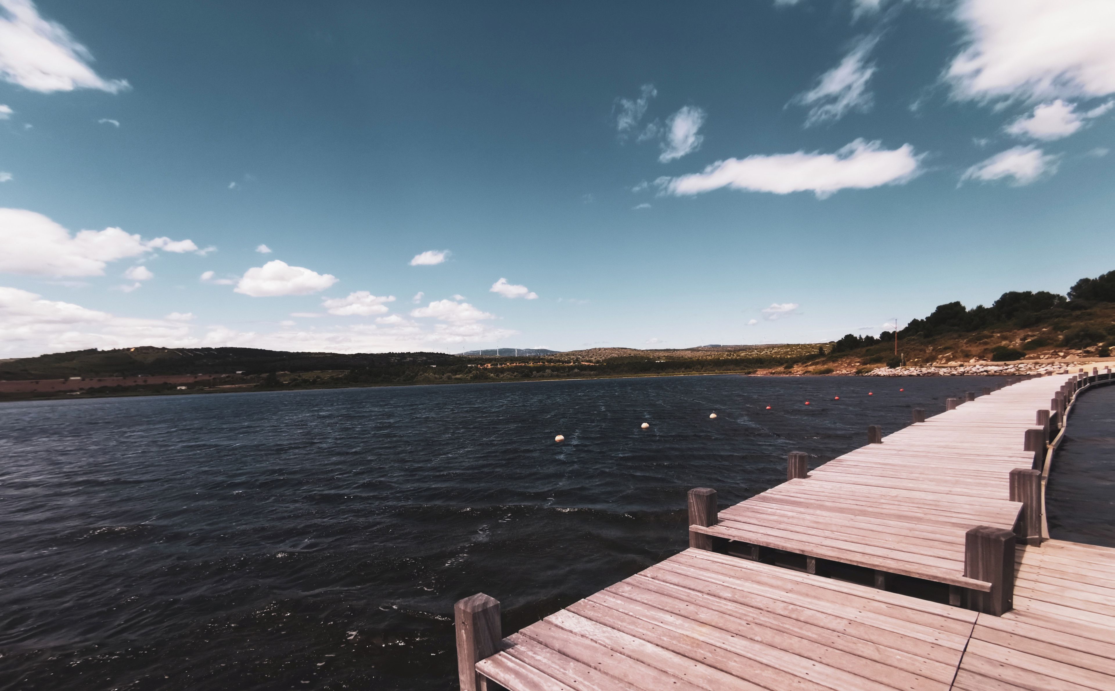A wooden pier extending into a body of water with a clear sky above.