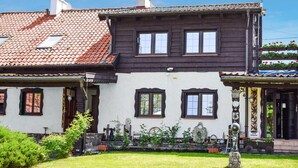 A traditional two-story building with a tiled roof and a well-maintained garden. - Beautiful apartment in Rydzewo with WiFi (Rydzewo)