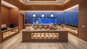 Una barra de desayuno moderna con una isla central, paneles de madera y un salpicadero de azulejos azules.