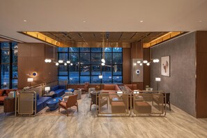 A modern hotel lobby with seating areas, large windows, and contemporary lighting fixtures. - Crystal Orange Hotel Yancheng Municipal Government (Yancheng)