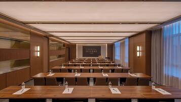 A conference room with multiple tables, chairs, and a projection screen displaying "CRYSTAL ORANGE."