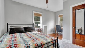 A bedroom with a bed, a desk, and a chair. - Cozy home with office walking distance to beach (Rochester)