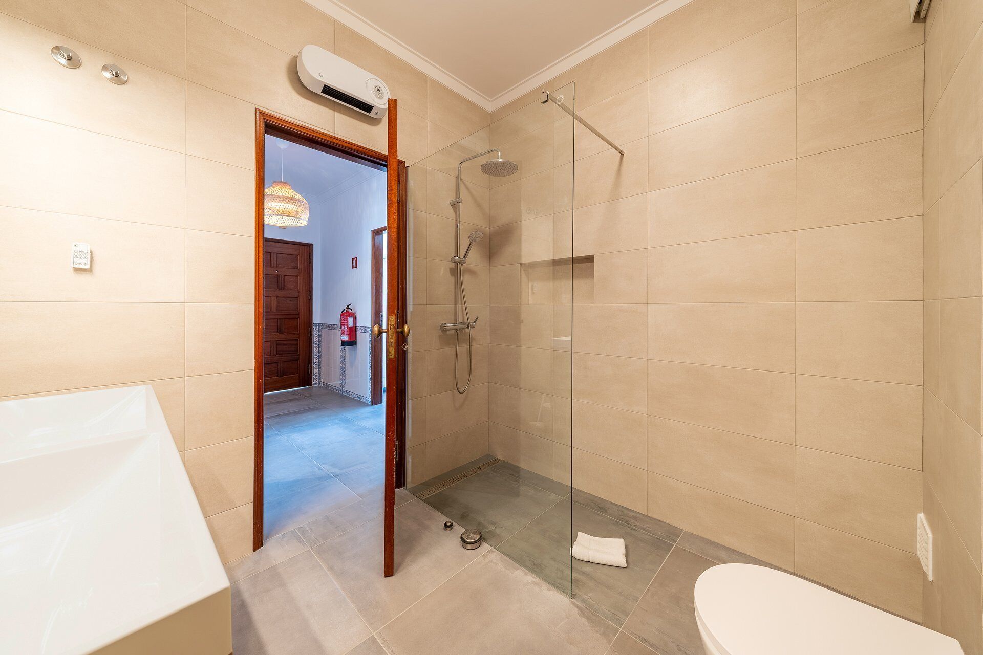 A bathroom with a shower, toilet, and a sink.