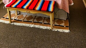 A hotel room with a large bed, two bedside lamps, a colorful bench, and a patterned headboard. - The Starlight at Casa Hermosa, Gaze At Sleeping Lion Mountain From Your Porch! (Fort Davis)