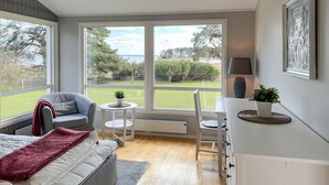 A modern bedroom with a large window, a bed, a chair, a small table, and a desk. - Amazing home in Rockneby with WiFi (Rockneby)