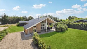 A modern house with a sloped roof, large windows, and a covered patio area. - Gorgeous home in Tarm with WiFi (Tarm)