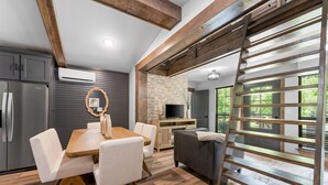 A modern kitchen with a dining area, a TV, and a large window with a view. - Creek Swimming Boulder Hot Tub Close Buffalo River (Marshall)