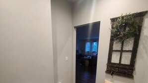 A hallway with wooden flooring, a bench, and a wall-mounted shelf with a plant. - Residential Home 3 miles from Brennand Airport and 20 miles from EAA.  (Oshkosh)