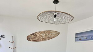 Un salon avec un canapé marron, une table à manger en bois et un lampadaire.