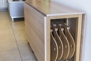 Un meuble en bois avec un porte-chaussures intégré, placé contre un mur.
