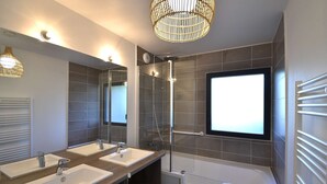 A modern bathroom with two sinks, a shower, and a large mirror. - Hossegor “VILLA BARRANX” Magnificent apartment for 4 people. (HOSSEGOR)