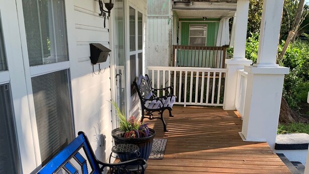Une terrasse en bois avec un banc bleu et une petite table sur laquelle sont disposées des huîtres.