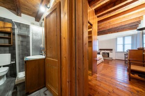 Un intérieur en bois comprenant une salle de bain, une porte en bois et un lit dans une pièce.
