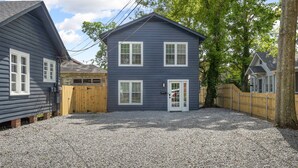 A two-story house with a gravel driveway and wooden fences.