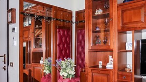 Une pièce dotée de meubles en bois, d’un paravent en velours rouge et d’un miroir orné d’un cadre en métal décoratif.