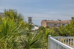 Una zona residencial costera con un faro destacado, casas escalonadas y abundante vegetación.