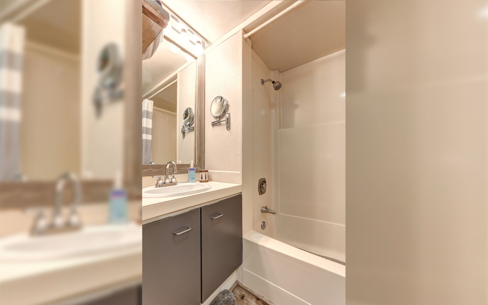A modern bathroom with a double sink, a mirror, a shower, and a vanity with drawers.