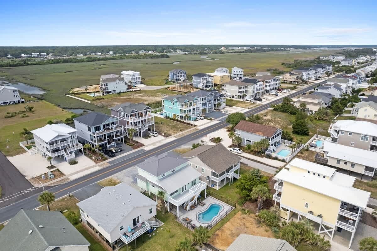 A residential area with houses, a road, and a swimming pool.