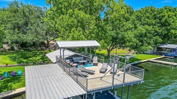 A multi-level dock with a covered seating area, a pool, and a boat ramp.