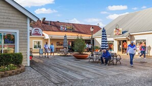 Un paseo marítimo con diversas tiendas, incluyendo una heladería artesanal y un pub y parrilla.