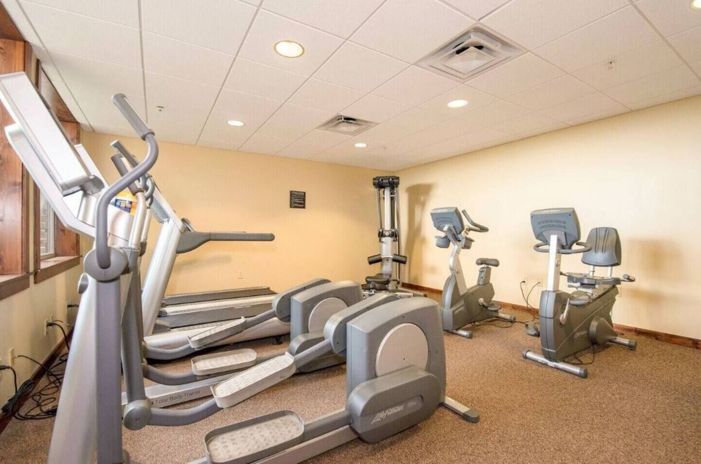 A fitness center with treadmills, elliptical machines, and a stair climber.
