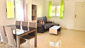 Un salon moderne comprenant un coin repas, un canapé et une petite table.