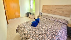 Une chambre à coucher avec un lit, une tête de lit en bois, une table de chevet, une lampe et une armoire.