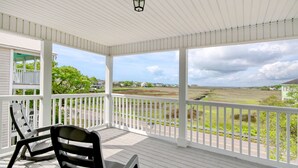 A covered porch with white railings and a view of a grassy landscape. - Spacious Beach House, Private Pool, Short Walk to the Beach, Bikes Welcome (Murrells Inlet)