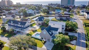 A residential area with houses, a swimming pool, and a road. - Spacious Beach House, Private Pool, Short Walk to the Beach, Bikes Welcome (Murrells Inlet)