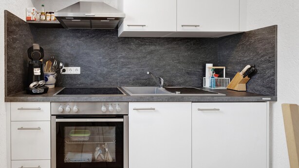 A modern kitchen with a built-in oven, a sink, and a stove.