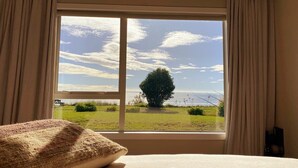 Una habitación con un ventanal que ofrece vistas a un campo cubierto de hierba y un árbol.