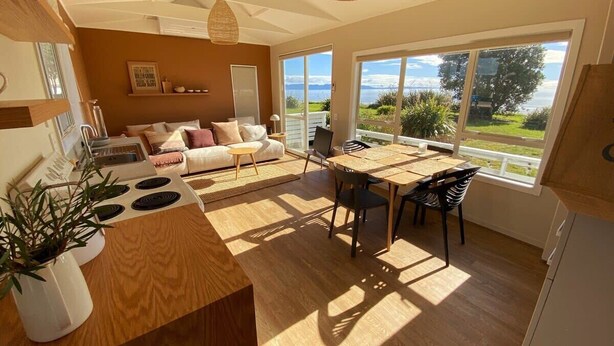 Una cocina moderna con comedor, ventanas amplias con vistas y una zona de estar acogedora.