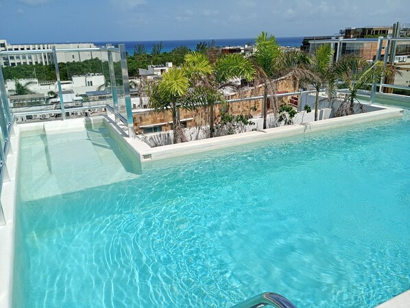 Relax by the rooftop pool surrounded by lush greenery and take in the panoramic views of the city and ocean.