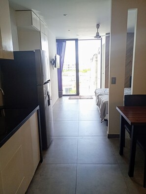 Enjoy a compact room with a kitchenette, dining table, and single bed, plus a balcony with a view of the surrounding area.