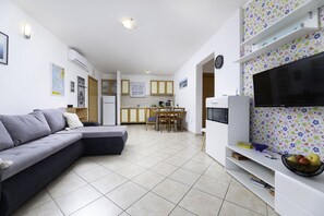 Relax in a spacious living area with a comfortable sofa and flat-screen TV, and enjoy meals at the dining table.