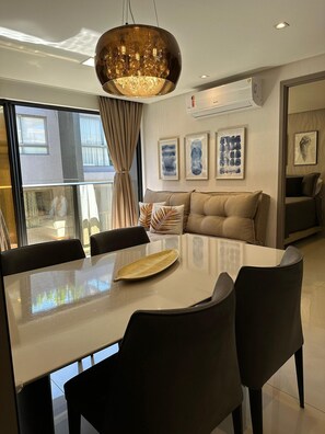 A modern dining area with a large table, chairs, and a decorative leaf centerpiece. - Fortune Cabo Branco (João Pessoa)