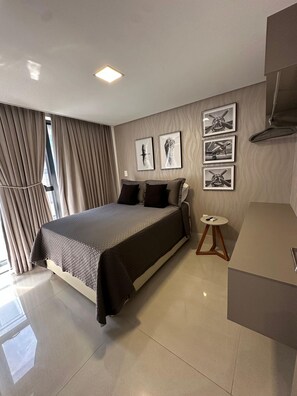 A modern bedroom with a large bed, a bedside table, and a wall-mounted TV.
