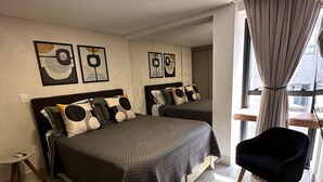 Un dormitorio moderno con una cama grande, una mesita de noche y una silla.