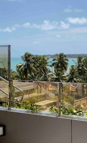 A balcony with a view of the ocean and palm trees. - Fortune Cabo Branco (João Pessoa)