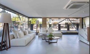 A modern living room with a sofa, armchairs, and a coffee table. - Fortune Cabo Branco (João Pessoa)