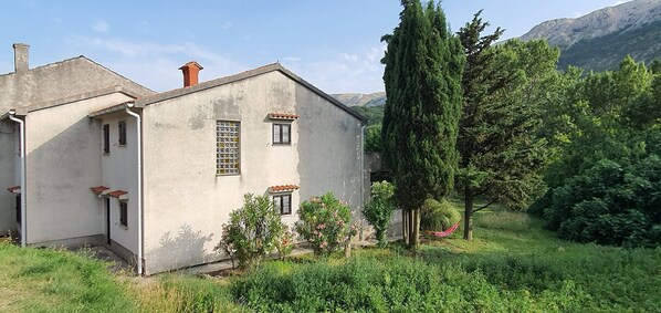 A rustic building with a sloped roof, a chimney, and a small porch.