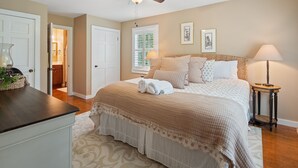 A bedroom with a bed, bedside table, lamp, ceiling fan, and a view of the bathroom. - Carols Cottage - Double decker dock! Popular location! (Cullman)