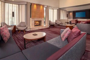 Ein modernes Wohnzimmer mit Kamin, grauen Sofas und einem Flachbildfernseher.