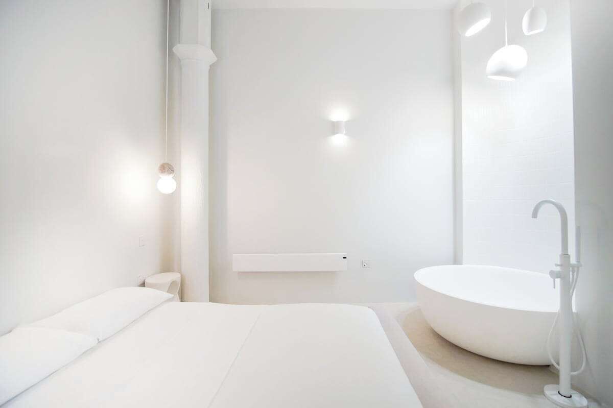 Une salle de bain moderne avec un grand lavabo ovale, des toilettes et un lit.