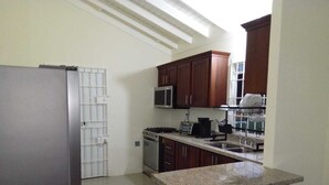 Una cocina equipada con refrigerador, estufa, microondas y lavavajillas.