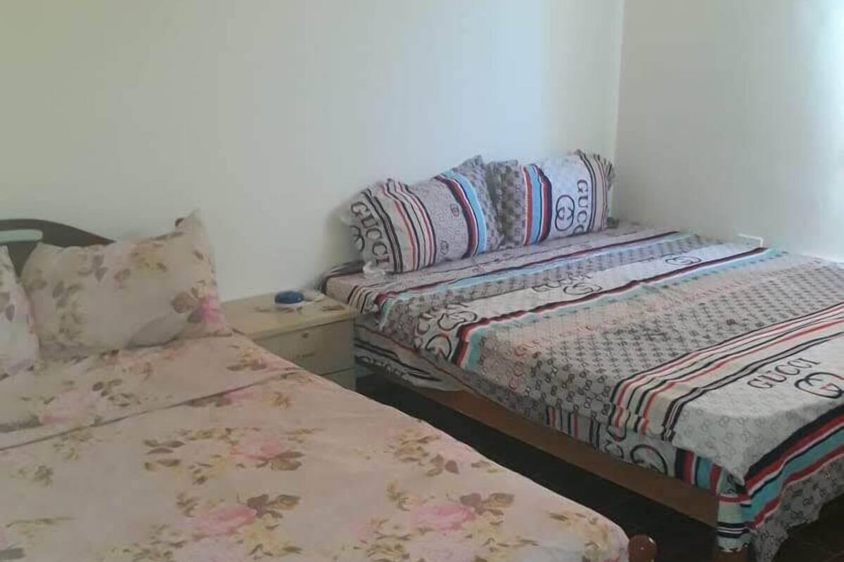 A bedroom with two single beds, each with floral and patterned bedding.