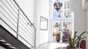 Een modern interieur met een glazen trap, een potplant en uitzicht op het buiten.