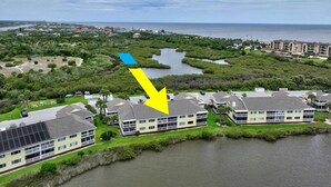 A residential area with houses near a water body, a marina, and a distant cityscape. - New Intracoastal Oasis | Flagler Beach | Intracoastal Views | Walk To The Beach | Solar Heated Pool (Flagler Beach)