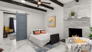 A modern bedroom with a bed, a sofa, a fireplace, and a ceiling fan. - Modern & Cozy Santa Fe Escape (Santa Fe)