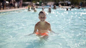 A swimming pool with clear water and people in the background. - Chalet on park with many facilities and pool (Vessem)